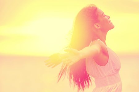 Woman taking a quiet, mindful moment outdoors at sunset